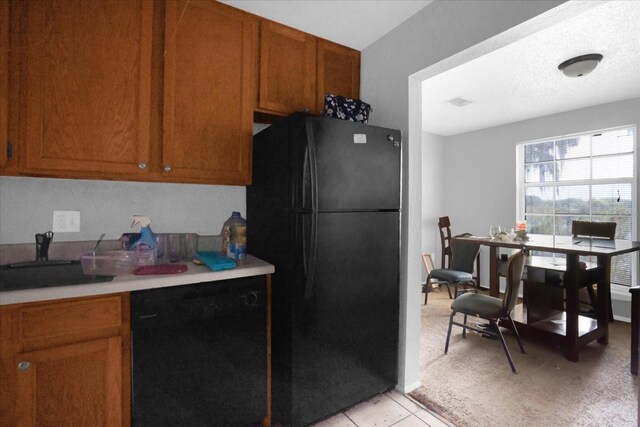 kitchen with sink, light tile patterned flooring, and black appliances