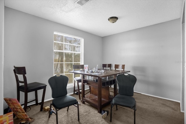 dining area with carpet floors and a textured ceiling