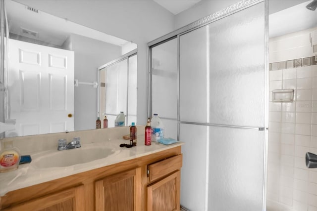 bathroom featuring vanity and an enclosed shower