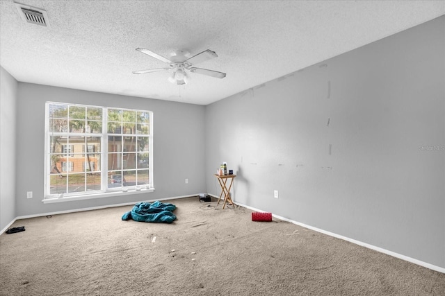 misc room featuring carpet, a textured ceiling, and ceiling fan