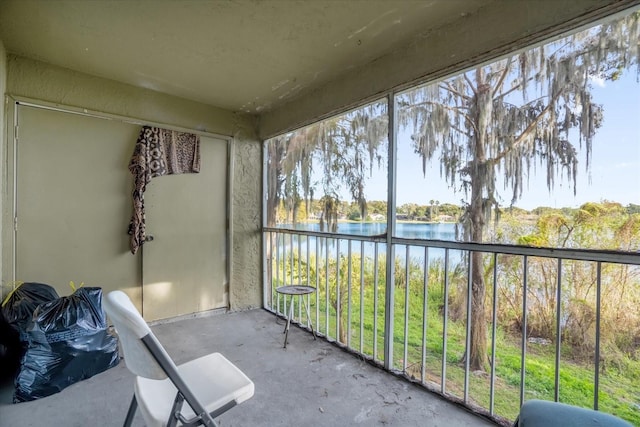 unfurnished sunroom featuring a water view