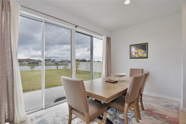 dining room featuring a water view and light tile patterned flooring