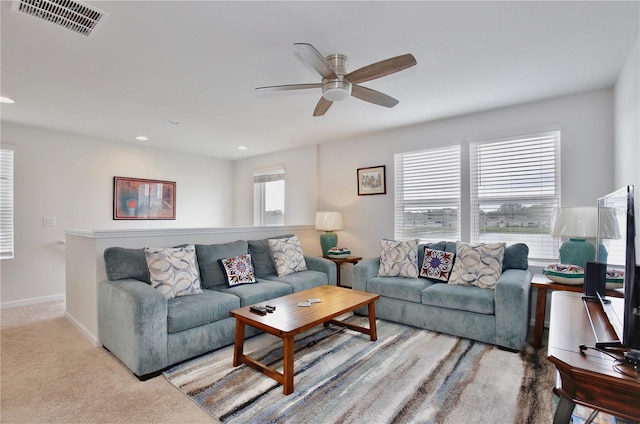 carpeted living room with ceiling fan