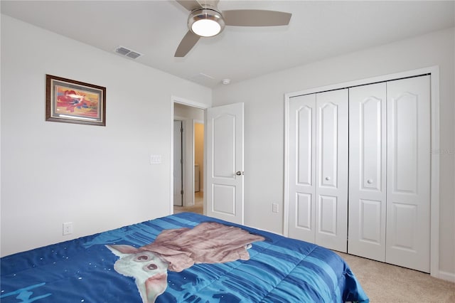 bedroom featuring ceiling fan, light carpet, and a closet