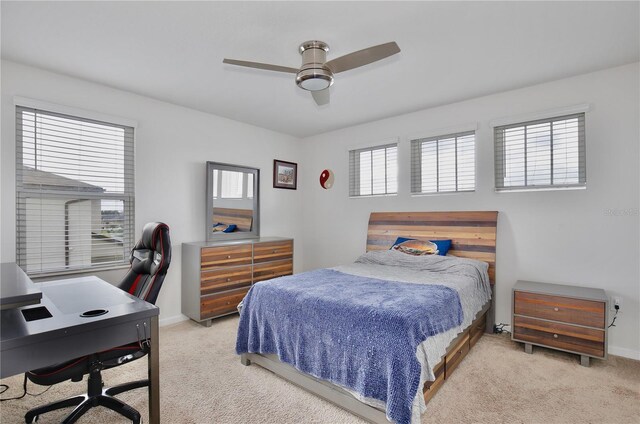 bedroom with light carpet, multiple windows, and ceiling fan