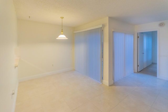 tiled spare room with a textured ceiling