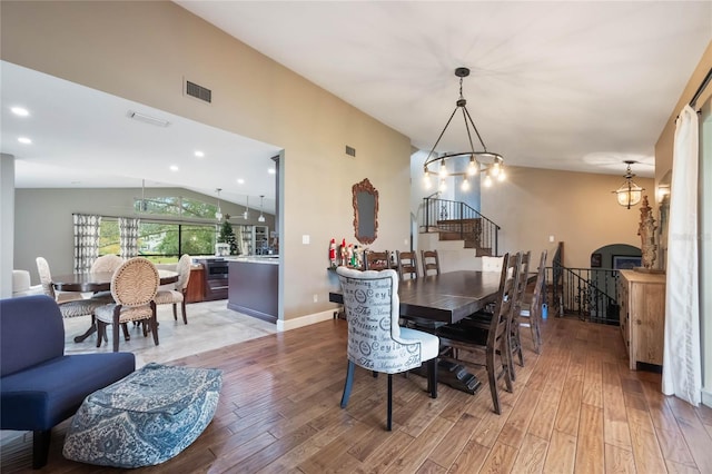 dining room with light hardwood / wood-style flooring, a chandelier, and lofted ceiling