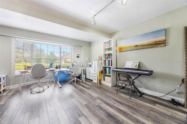 office space with wood-type flooring and track lighting