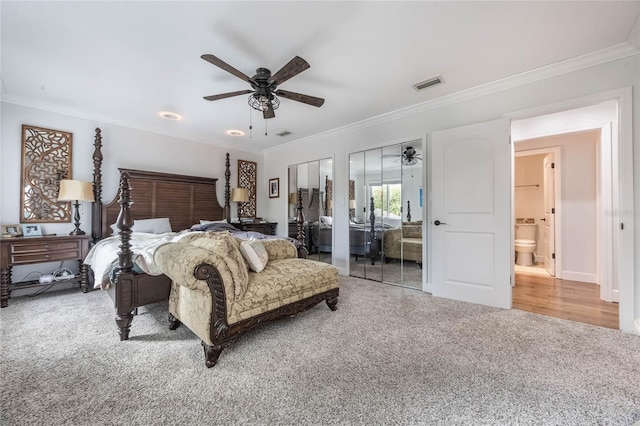 carpeted bedroom with two closets, ceiling fan, and ornamental molding