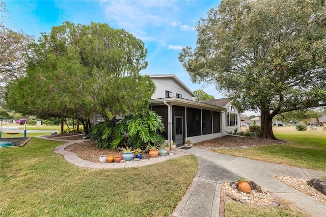 view of front of home with a sunroom and a front yard