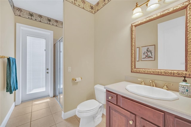 bathroom with an enclosed shower, vanity, tile patterned floors, and toilet