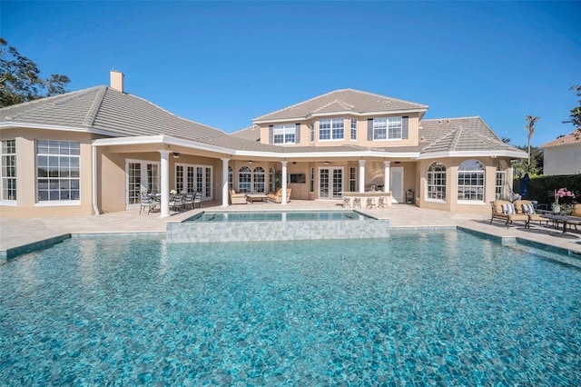 view of pool featuring french doors, ceiling fan, an in ground hot tub, and a patio area