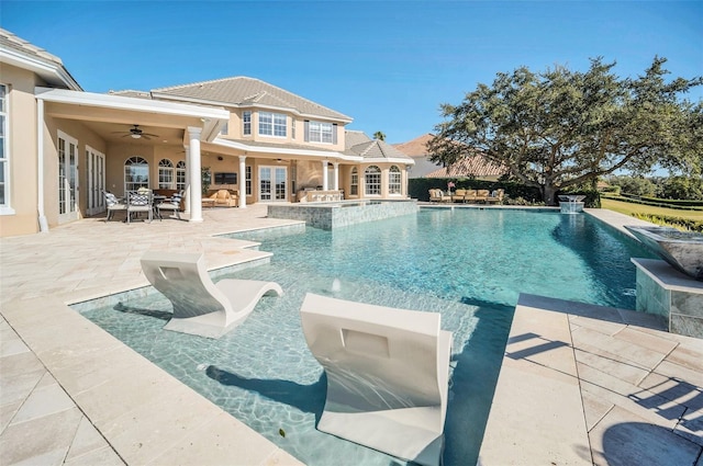 view of swimming pool with a patio area, pool water feature, and ceiling fan