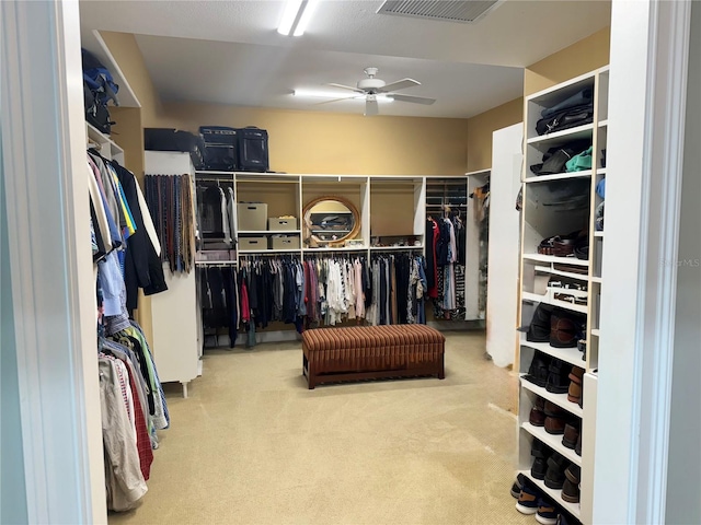 walk in closet with ceiling fan and light carpet