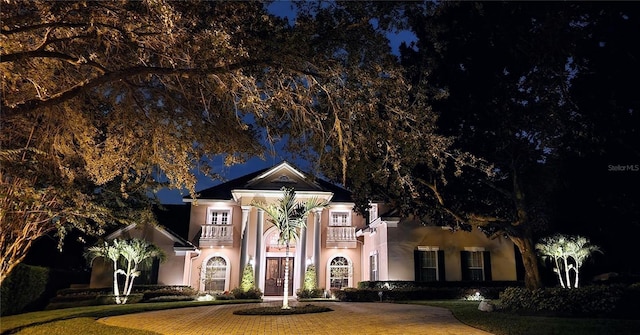 neoclassical home featuring a lawn