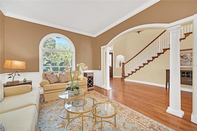 living room with ornate columns, wood-type flooring, and crown molding