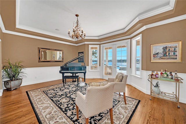 sitting room featuring ornamental molding, a chandelier, light wood-type flooring, and french doors