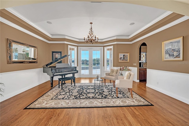 sitting room featuring wood-type flooring, ornamental molding, and french doors