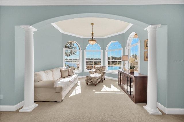 living room featuring carpet floors, ornamental molding, and decorative columns