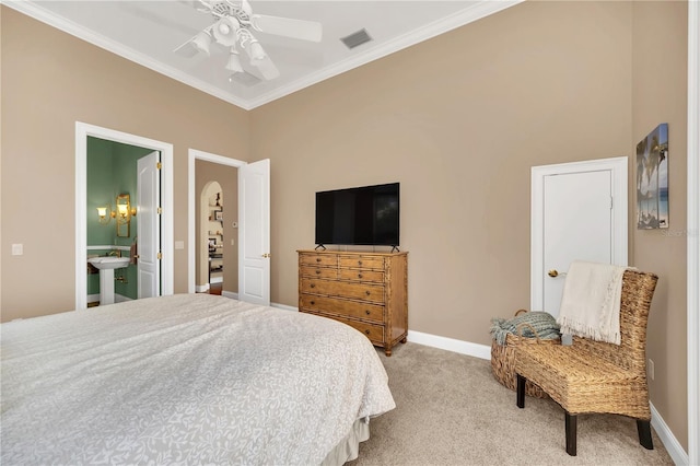 carpeted bedroom with crown molding, ensuite bathroom, and ceiling fan