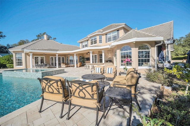 rear view of house featuring a patio area, ceiling fan, and french doors