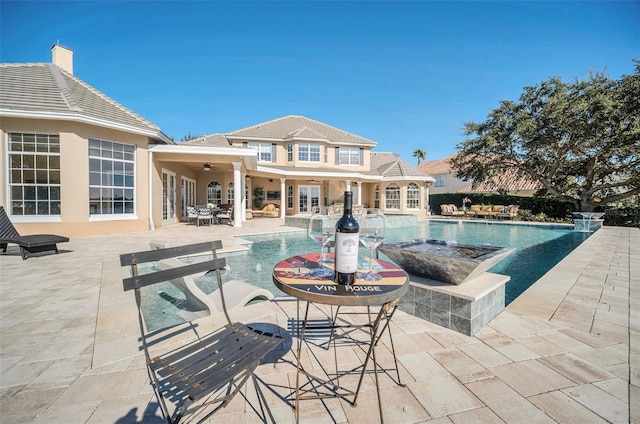 view of swimming pool with an outbuilding, ceiling fan, and a patio area