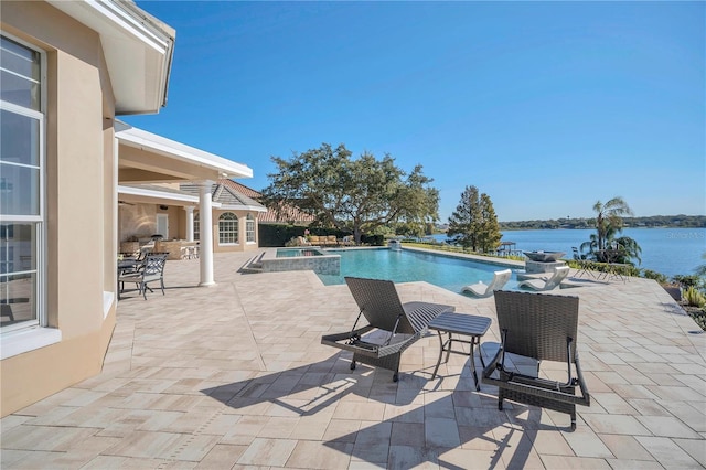 view of swimming pool featuring a patio and a water view