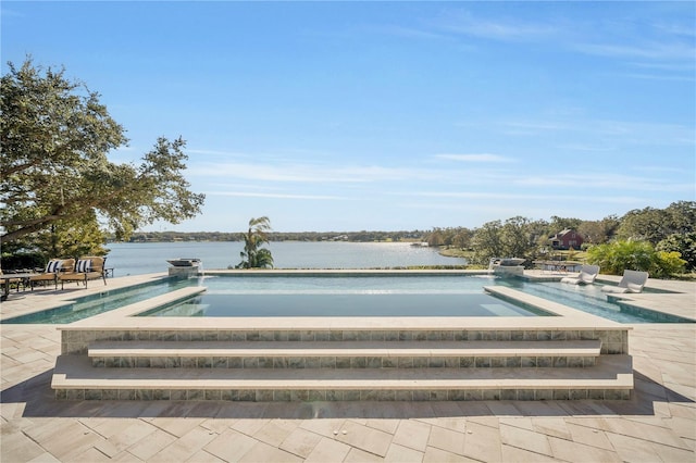 view of swimming pool featuring a water view, a jacuzzi, and a patio