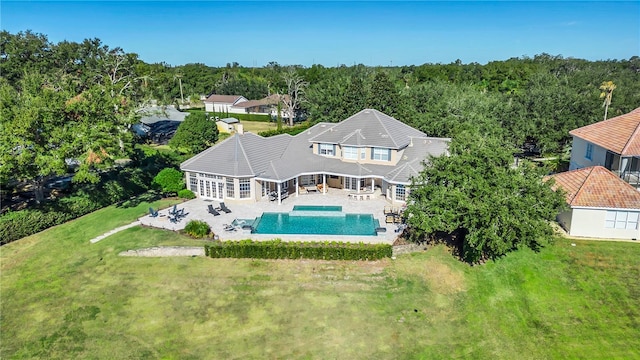 rear view of house featuring a lawn and a patio