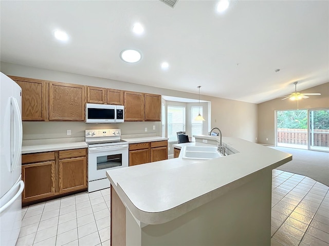 kitchen featuring white appliances, a kitchen island with sink, hanging light fixtures, and vaulted ceiling