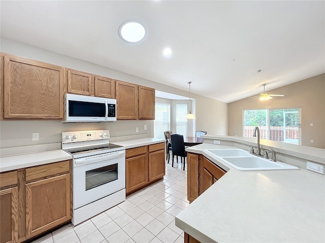 kitchen featuring white appliances, vaulted ceiling, a wealth of natural light, and sink