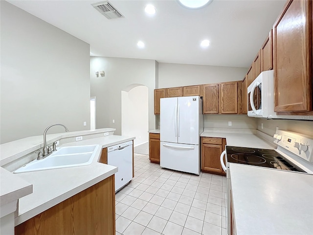 kitchen featuring lofted ceiling, white appliances, sink, and light tile patterned floors