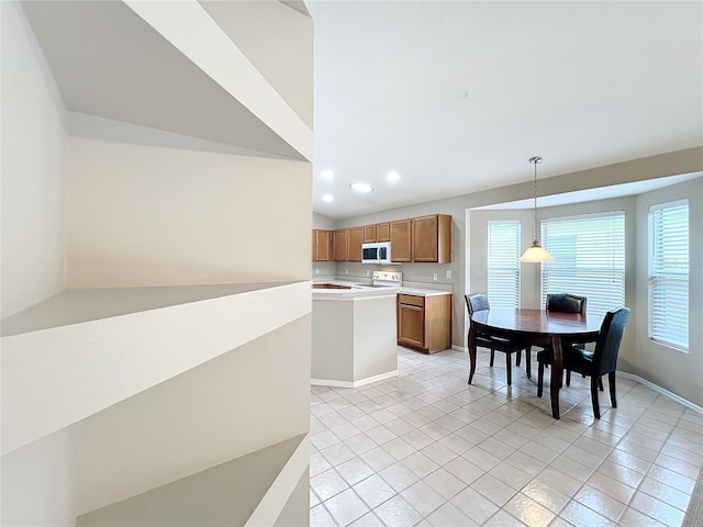 kitchen featuring decorative light fixtures, white appliances, light tile patterned floors, and vaulted ceiling