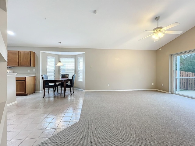 tiled dining area featuring vaulted ceiling, plenty of natural light, and ceiling fan