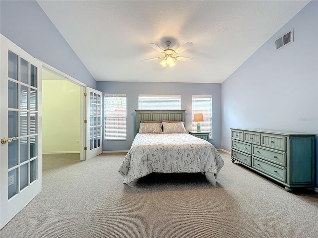 bedroom with ceiling fan, vaulted ceiling, light carpet, and multiple windows