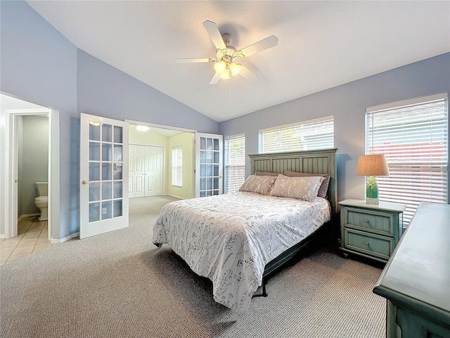 carpeted bedroom featuring ensuite bathroom, vaulted ceiling, and ceiling fan