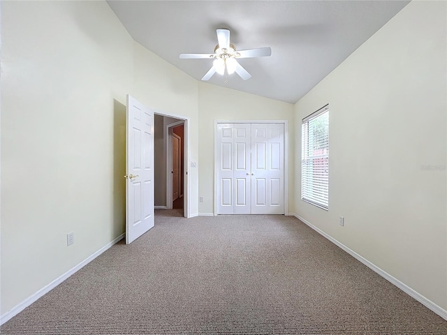 unfurnished bedroom with ceiling fan, light colored carpet, lofted ceiling, and a closet