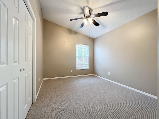 unfurnished bedroom with a textured ceiling, ceiling fan, lofted ceiling, and carpet floors