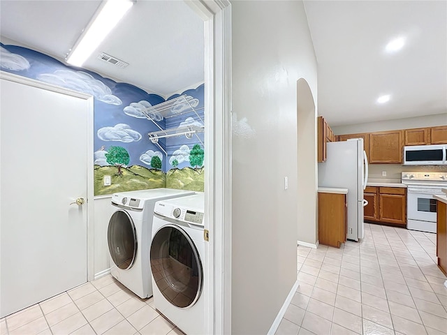 laundry room featuring light tile patterned floors and washing machine and dryer