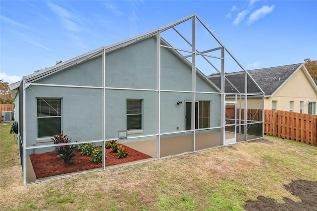 back of house featuring a lanai and a yard