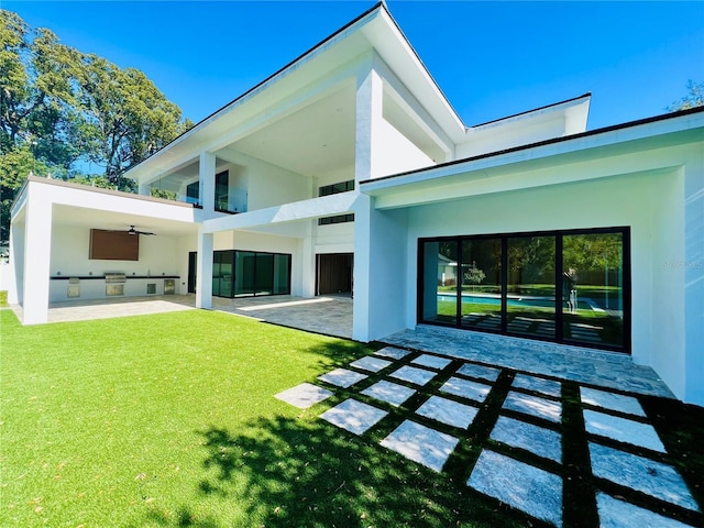 back of house with a yard, area for grilling, ceiling fan, and a patio area