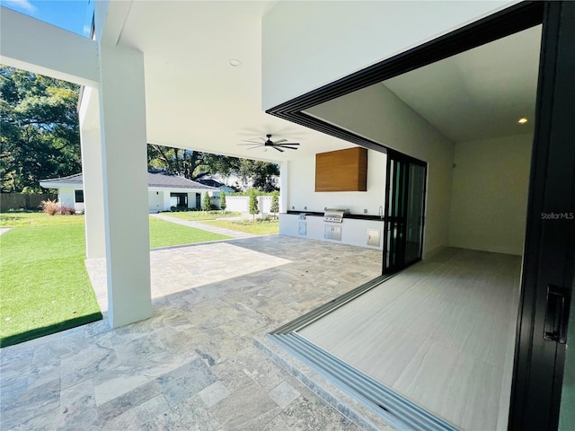 view of patio with ceiling fan, exterior kitchen, and grilling area