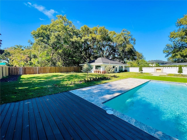 view of pool with a lawn and a wooden deck