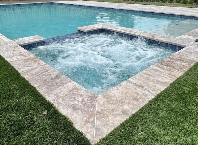 view of pool with an in ground hot tub and a yard