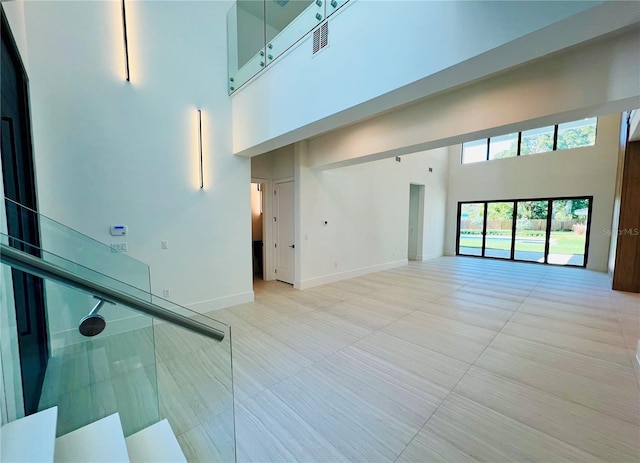 interior space featuring light tile patterned floors and a high ceiling