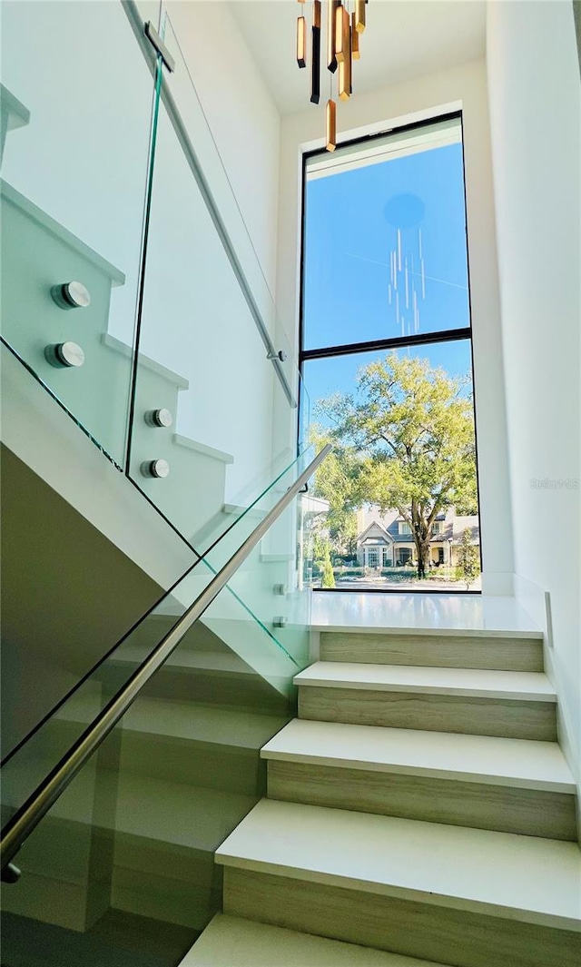 stairs featuring an inviting chandelier