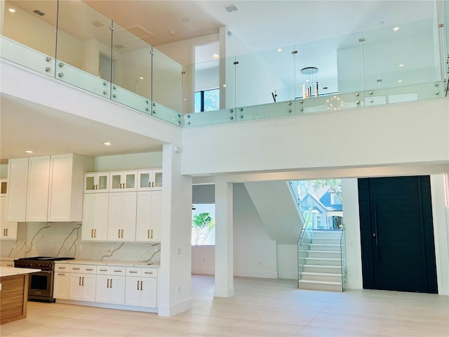 interior space featuring a wealth of natural light, light hardwood / wood-style floors, and a high ceiling