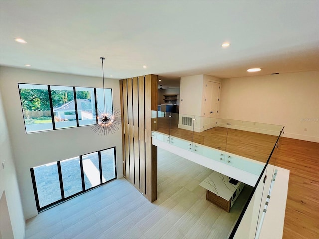 kitchen with white cabinets, light hardwood / wood-style flooring, hanging light fixtures, and ceiling fan