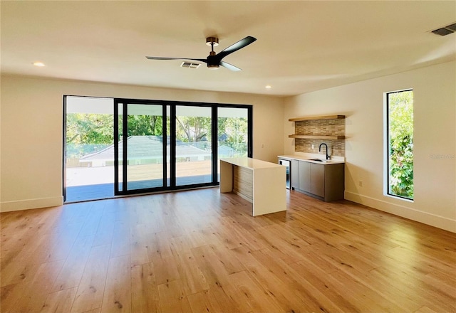 interior space featuring light hardwood / wood-style floors, wine cooler, ceiling fan, and sink