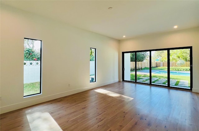 unfurnished room with a healthy amount of sunlight and light wood-type flooring